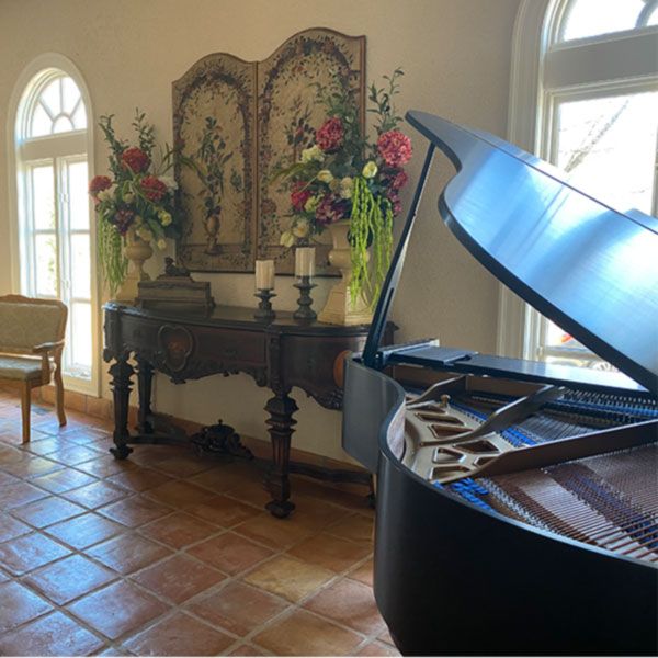 A large room at Tuscan Ridge for a gathering with baby grand piano