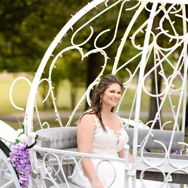 A bride smiling as she enters Tuscan Ridge in horse and buggy carriage.