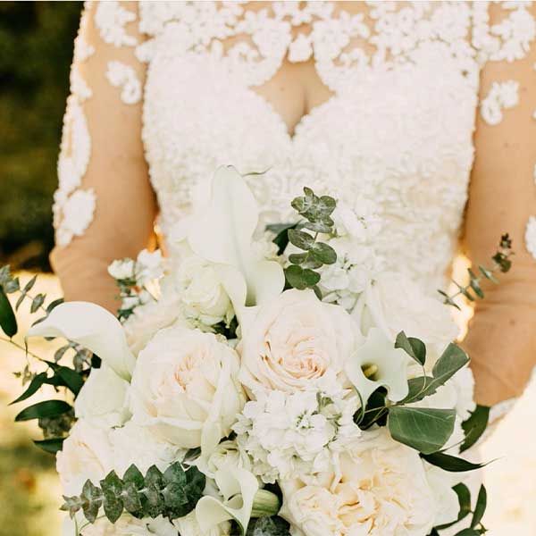 Bride holding her bouquet of roses as she enters the wedding ceremony